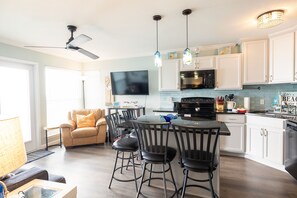 Enjoy cooking and dining in this well-equipped kitchen with a central island, flat-screen TV, and stainless steel oven.