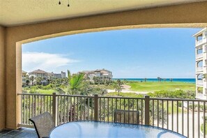 Een balkon met uitzicht op een golfbaan en de oceaan.
