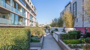 A modern apartment building with balconies, a narrow pathway, and well-maintained greenery. - Le Newport by Interhome (Fréjus)