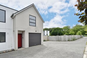 A modern two-story building with a red door and a garage.