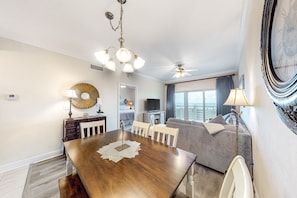 Cozy living area with a dining table for four, sofa, and TV, offering a city view.