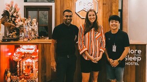 A reception area with wooden paneling, a reception desk, and a wall-mounted sign. - More than Sleep Hostel Pak Chong - Khao Yai (Pak Chong)