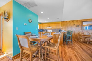 Una cocina con armarios de madera, una mesa redonda de comedor y sillas.