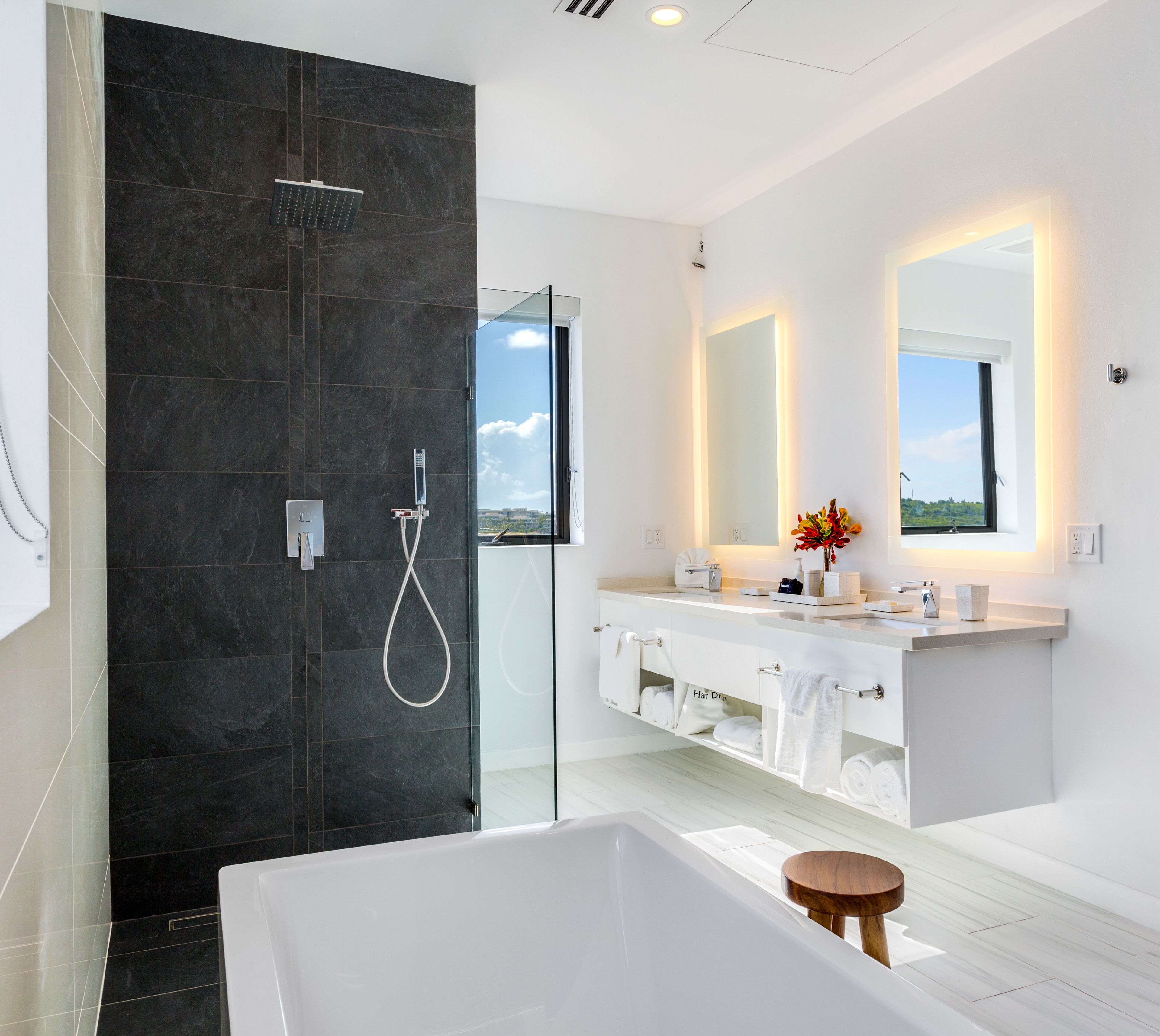 A modern bathroom with a large bathtub, a walk-in shower, and a vanity with a mirror.