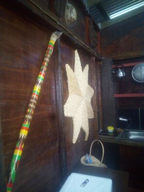 Un intérieur en bois orné d’un motif décoratif en forme d’étoile, d’un poteau rayé et d’une petite étagère sur laquelle sont posés divers objets.