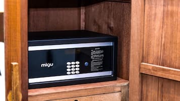 A black electronic device with a keypad and operating instructions in a wooden cabinet.