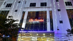 A hotel with a prominent neon sign reading "The Senator Hotel" and a modern architectural design. - The Senator Hotel (Kolkata)