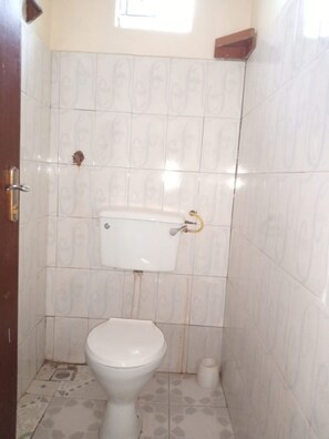 Bathroom features a toilet, sink, and patterned tiles.