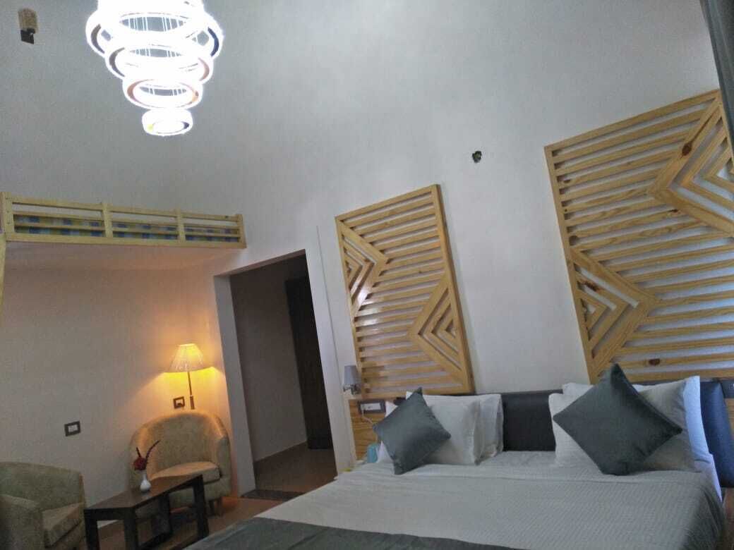 Une chambre d’hôtel avec un lit, une chaise, une lampe et des panneaux décoratifs en bois sur les murs.