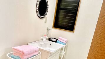 A bathroom with a sink, mirror, and a window.