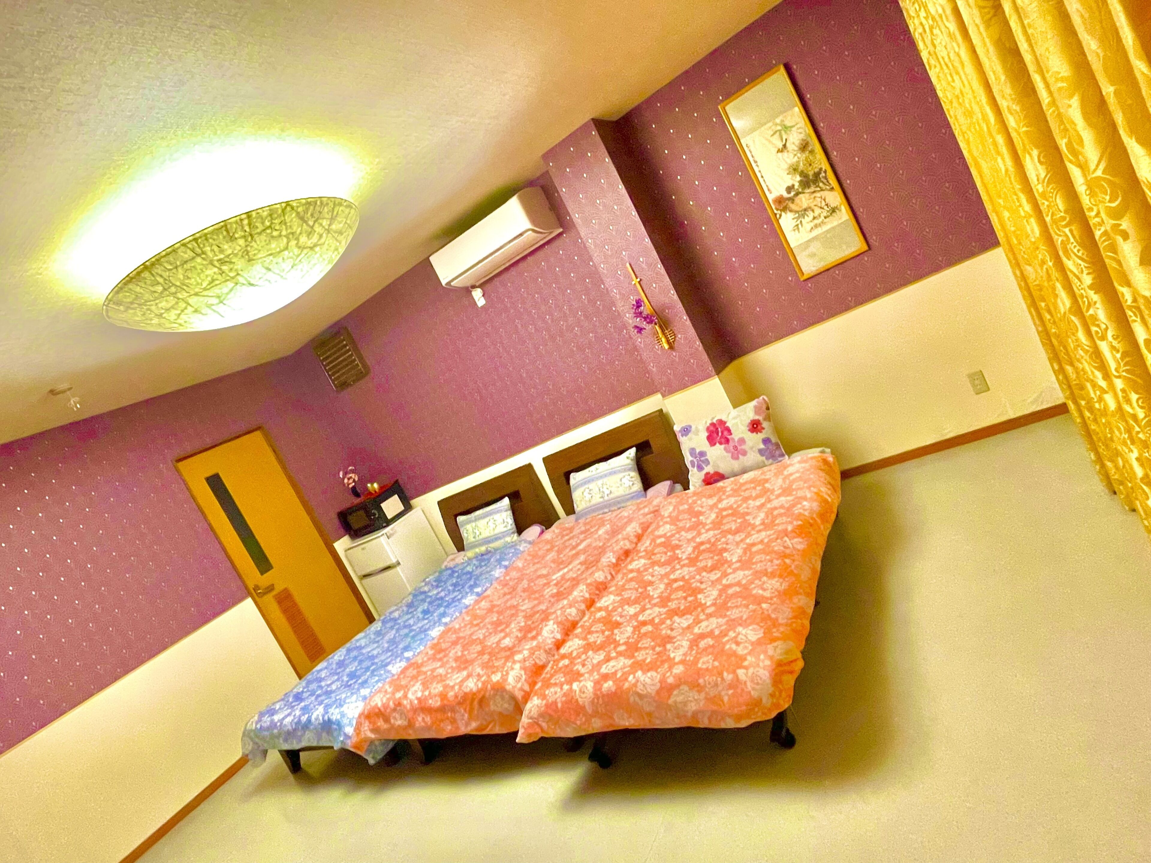 A bedroom with a bed, a desk, and a chair. There is a door and a window.