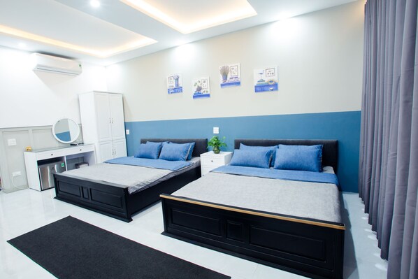 A modern bedroom with two beds, a desk, and a wardrobe. - Lalaland Hostel (Quy Nhon)