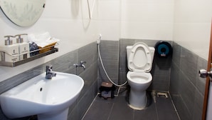 Un baño moderno con lavamanos blanco, inodoro y ducha.