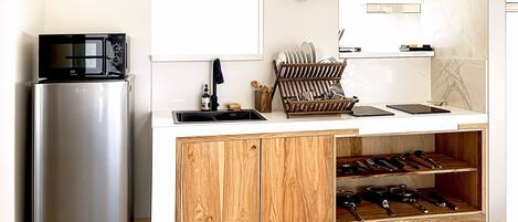 Una cocina moderna con un refrigerador de acero inoxidable, un microondas y gabinetes de madera.