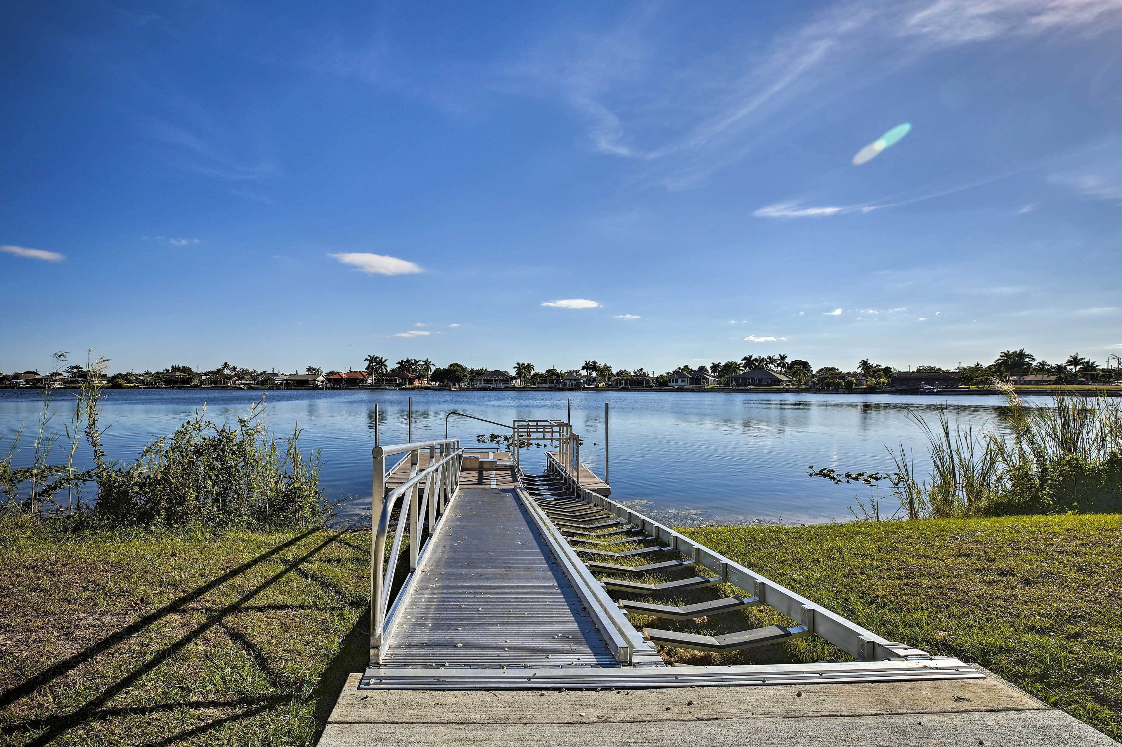Een betonnen steiger die uitsteekt in een kalm meer, met een heldere lucht.