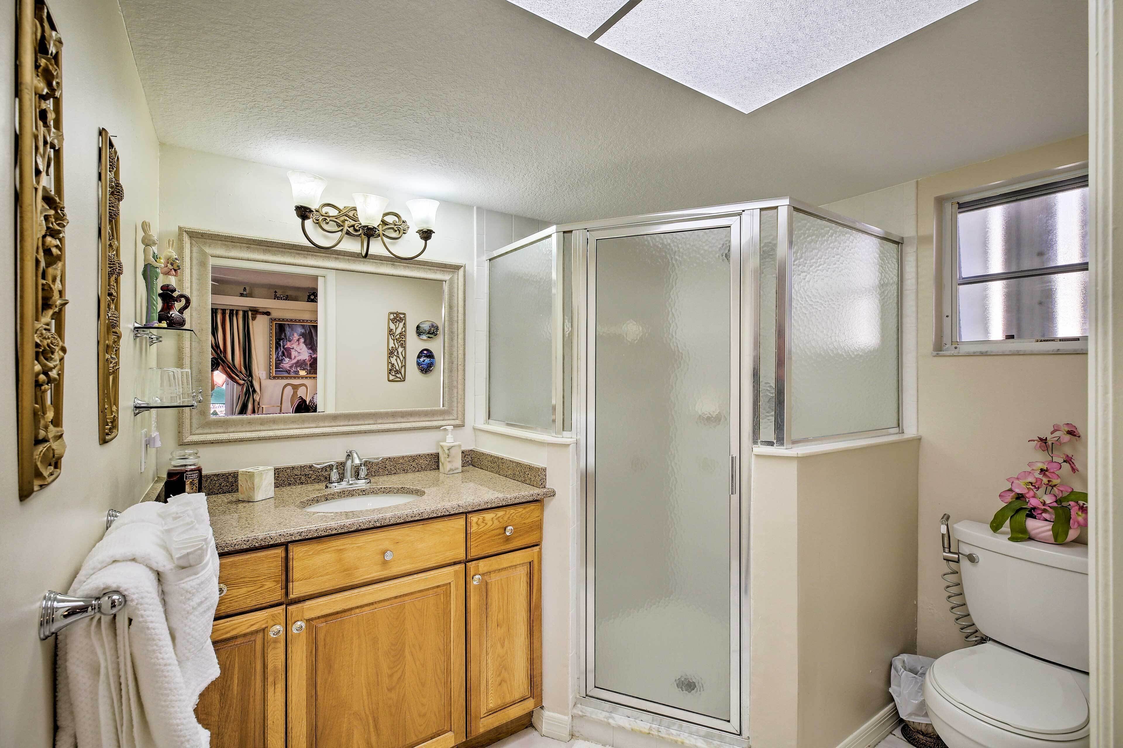 Een badkamer met douche, toilet en wastafel.