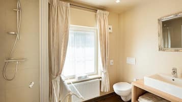 A bathroom with a shower, toilet, and sink.