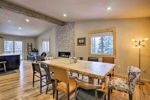 Un comedor amplio con una gran mesa de madera, sillas de cuero y una chimenea de piedra.