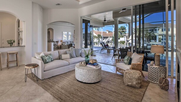 A spacious living room with a large sofa, a round coffee table, and a view of the outdoor patio area.
