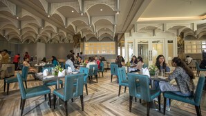 A spacious restaurant with teal chairs and a high ceiling with decorative arches. - Seven Eleven Club (Mumbai)