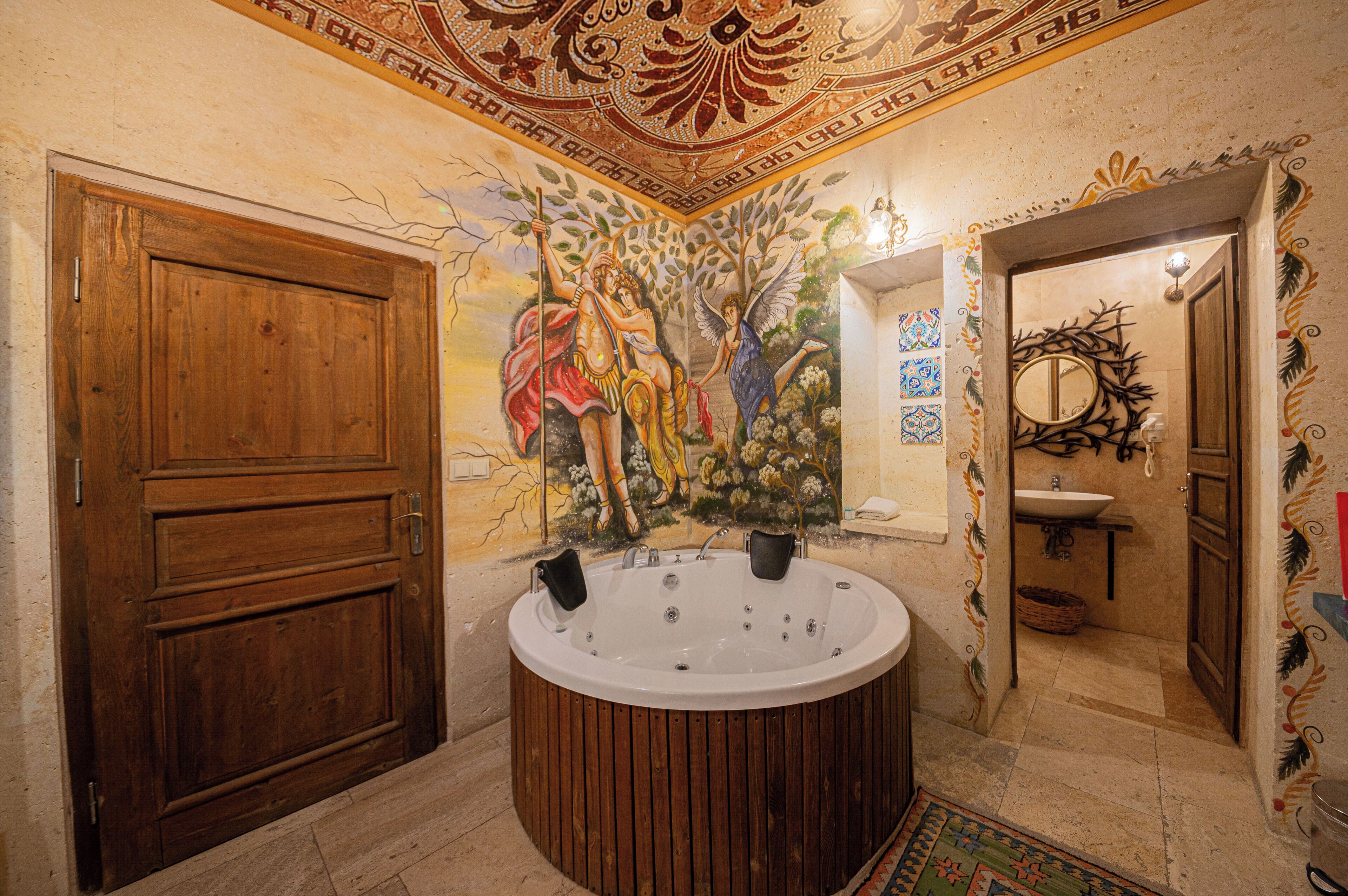 A bathroom with a wooden door, a bathtub, a mosaic wall, and a sink.
