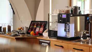A coffee station with a coffee machine, cups, and a variety of coffee pods.