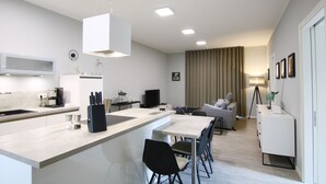 Une cuisine moderne avec un îlot central, un coin repas avec des chaises, un canapé et une lampe.