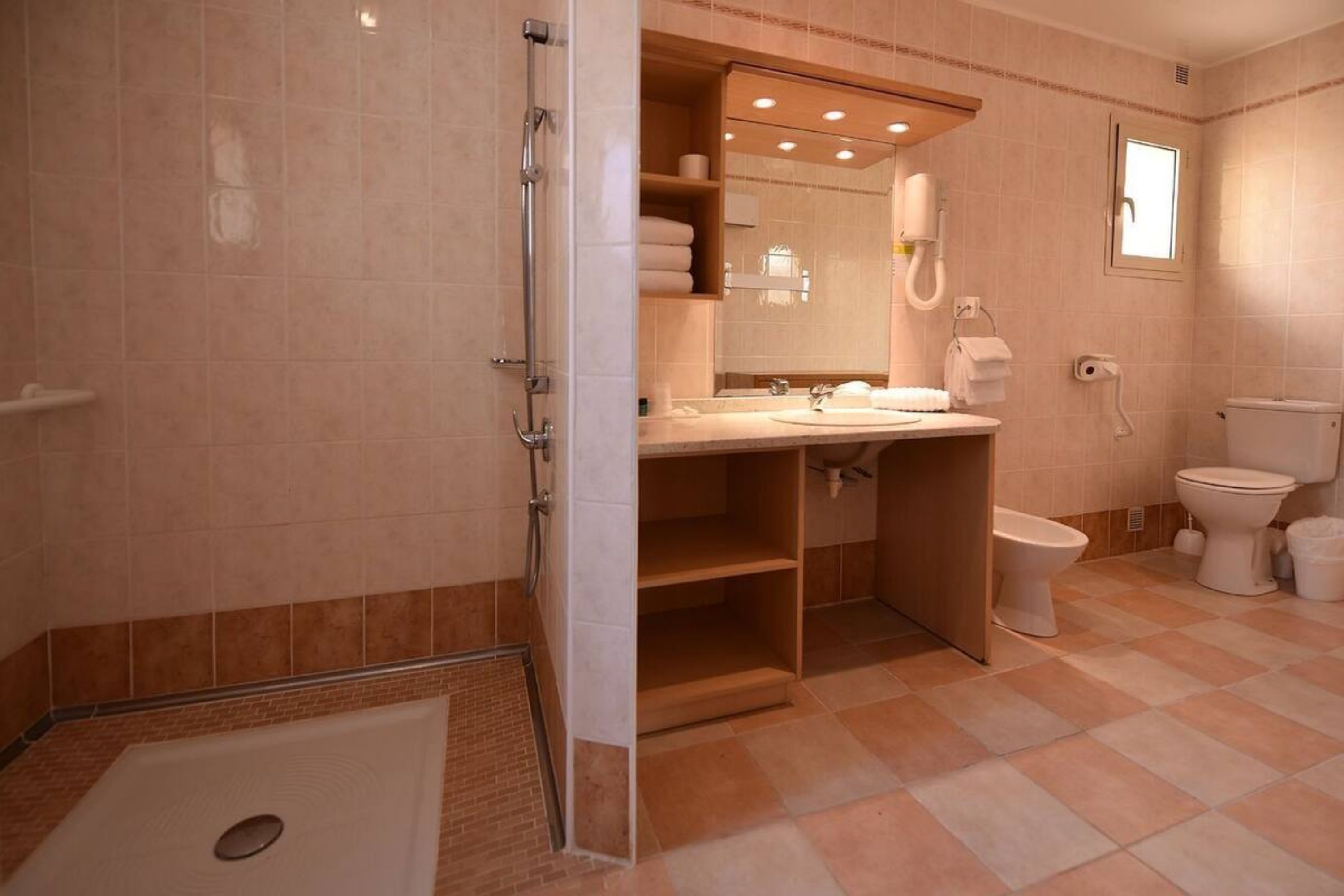 A bathroom with a shower, toilet, and sink.