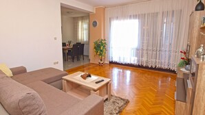 A living room with a sofa, coffee table, and a dining area in the background. - Apartment 1424/13309 (Istria - Pula), 2500m from the beach (Pula)