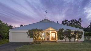 A single-story house with a garage, a sloped roof, and a small porch with a door. - Burnvale: spacious family home, 500m to beach, air-conditioned (Dunsborough)