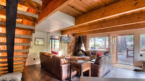 A cozy cabin interior with a fireplace, wooden floors, and a comfortable seating area. - Enchanting Chamberlands Cabin (Tahoma)