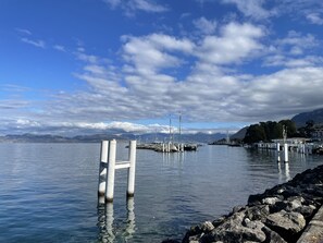 Un lac paisible, bordé d’une rive rocheuse, avec une jetée qui s’avance dans l’eau.