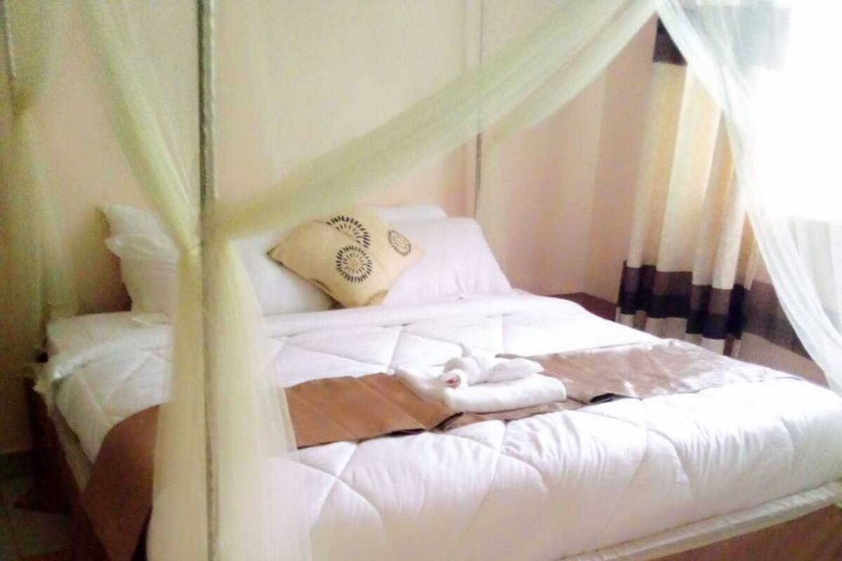 A bed with a canopy, a pillow, and a blanket.