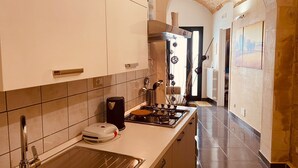 A modern kitchen with white cabinets, a stainless steel range hood, and a gas stove.