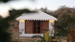 Un petit bâtiment blanc, d’un seul étage, avec un toit en pente, une porte centrale et deux fenêtres de chaque côté.