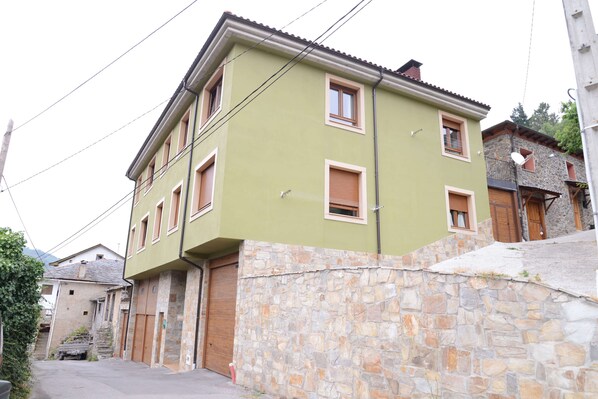 A two-story building with a stone facade and multiple windows.