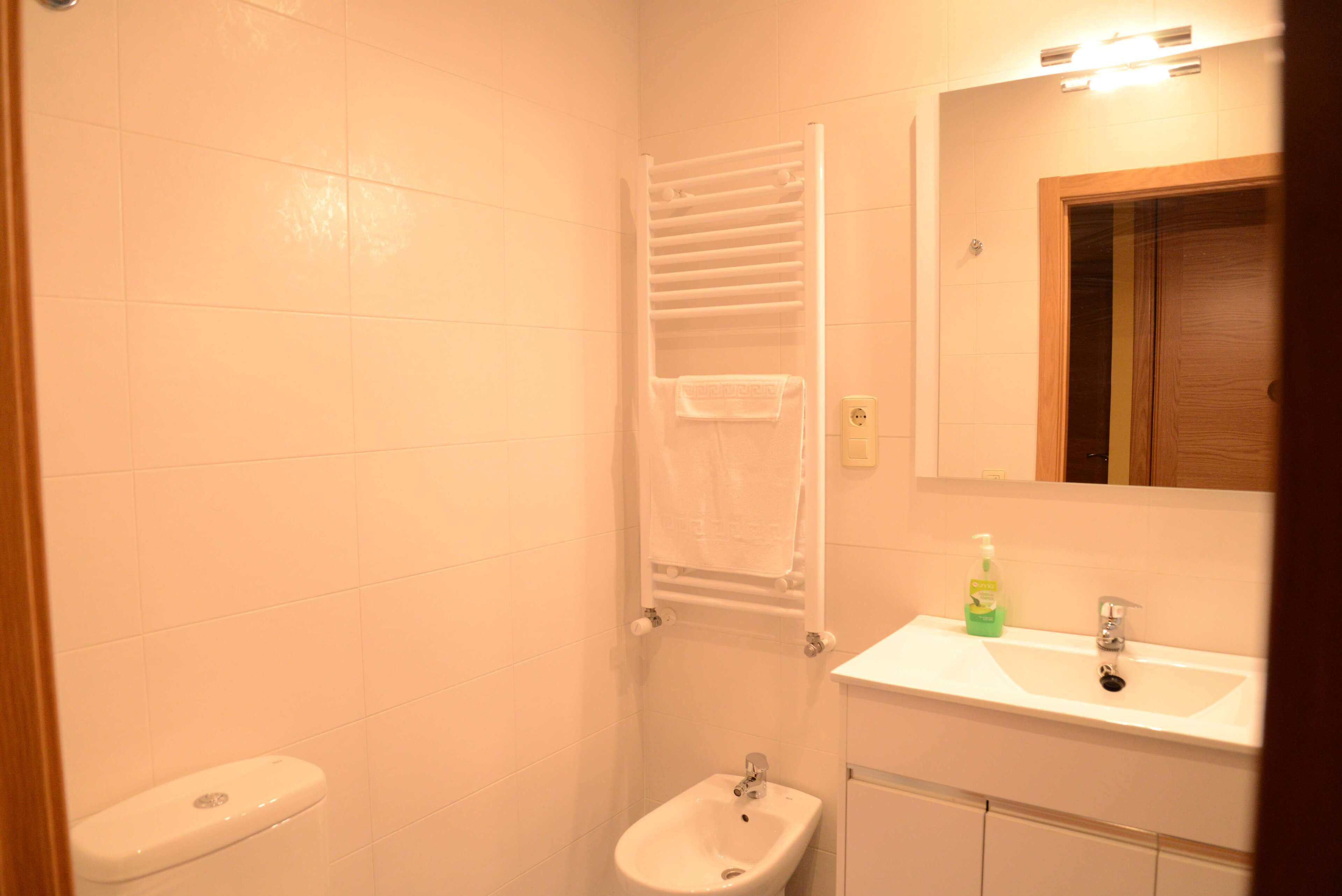 Un baño pequeño con inodoro, bidé y lavamanos.