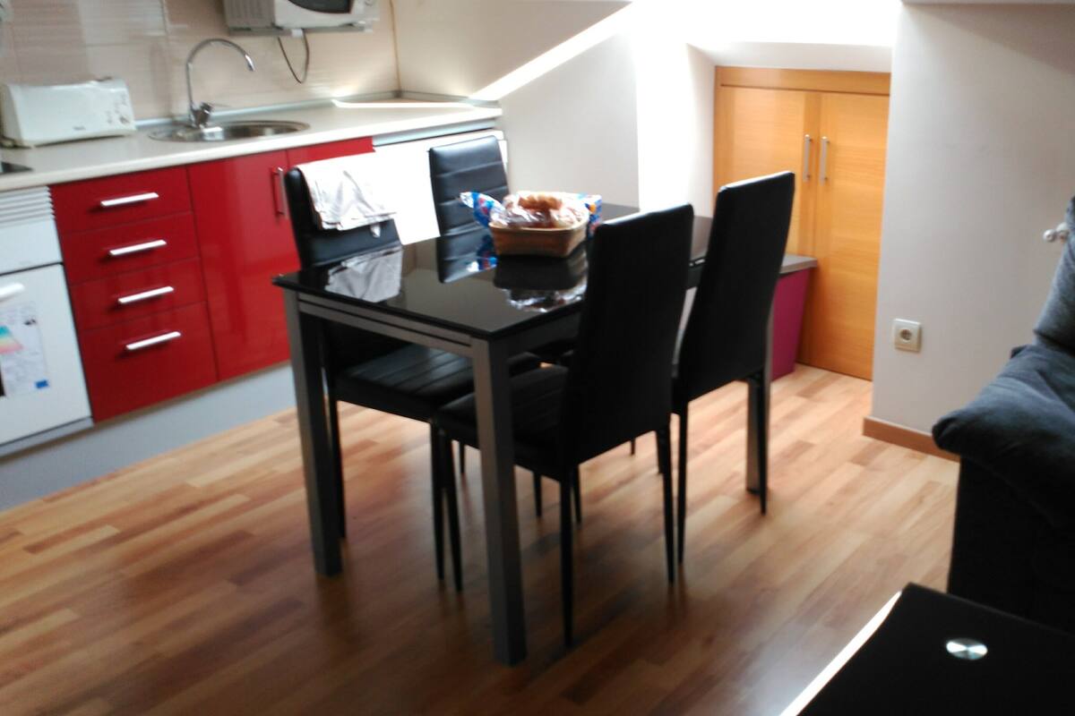 Um espaço compacto com área de refeições, cozinha compacta e sofá.