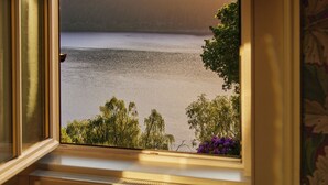 A room with a view of a lake and mountains through an open window. - Foyers Lodge (Inverness)