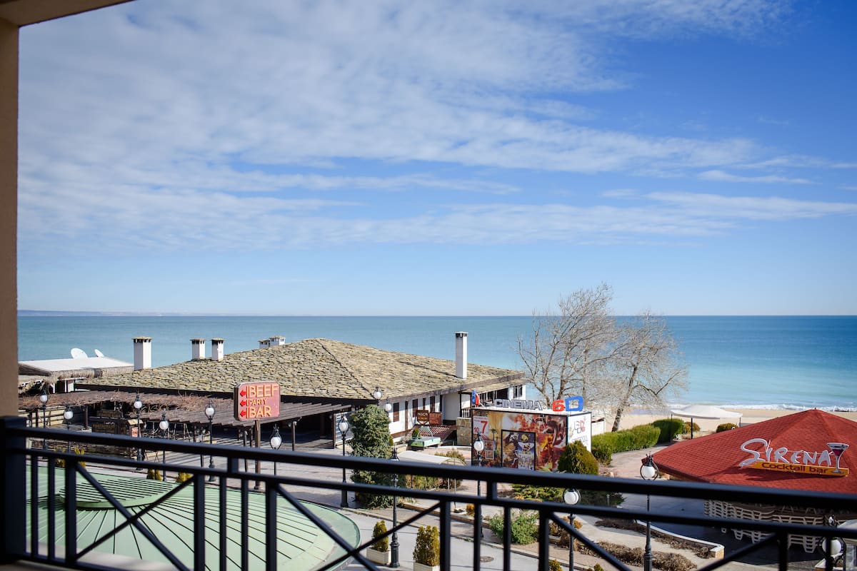 A coastal view with a beach, a bar named 'Sirenat', and a sign for 'BEEF PARTY BAR'.