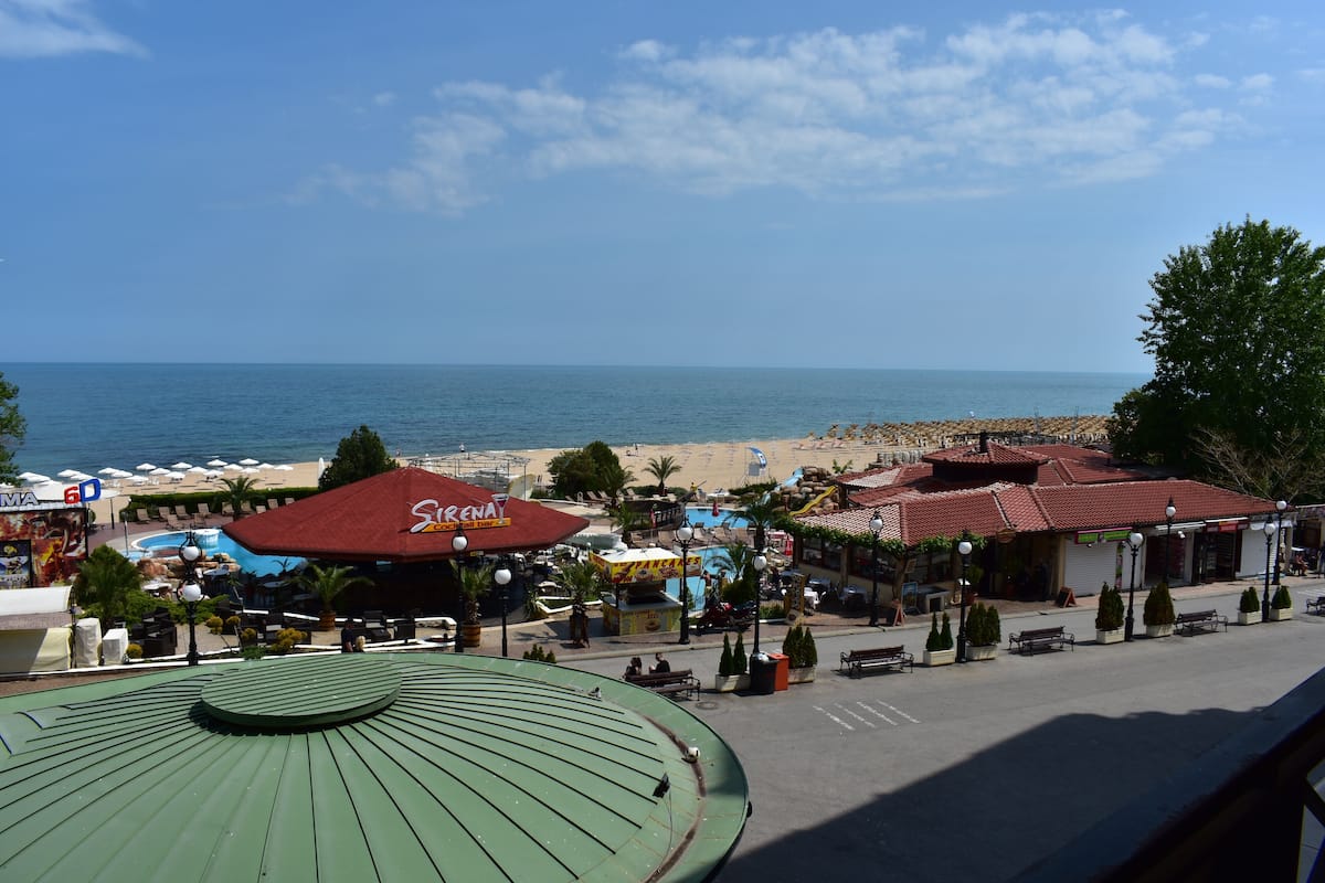 A coastal view with a beach, a restaurant named "Sirenia," and a pool area.