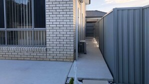 Ein modernes Gebäude mit Ziegelverkleidung, großen Fenstern und einem Metallzaun.