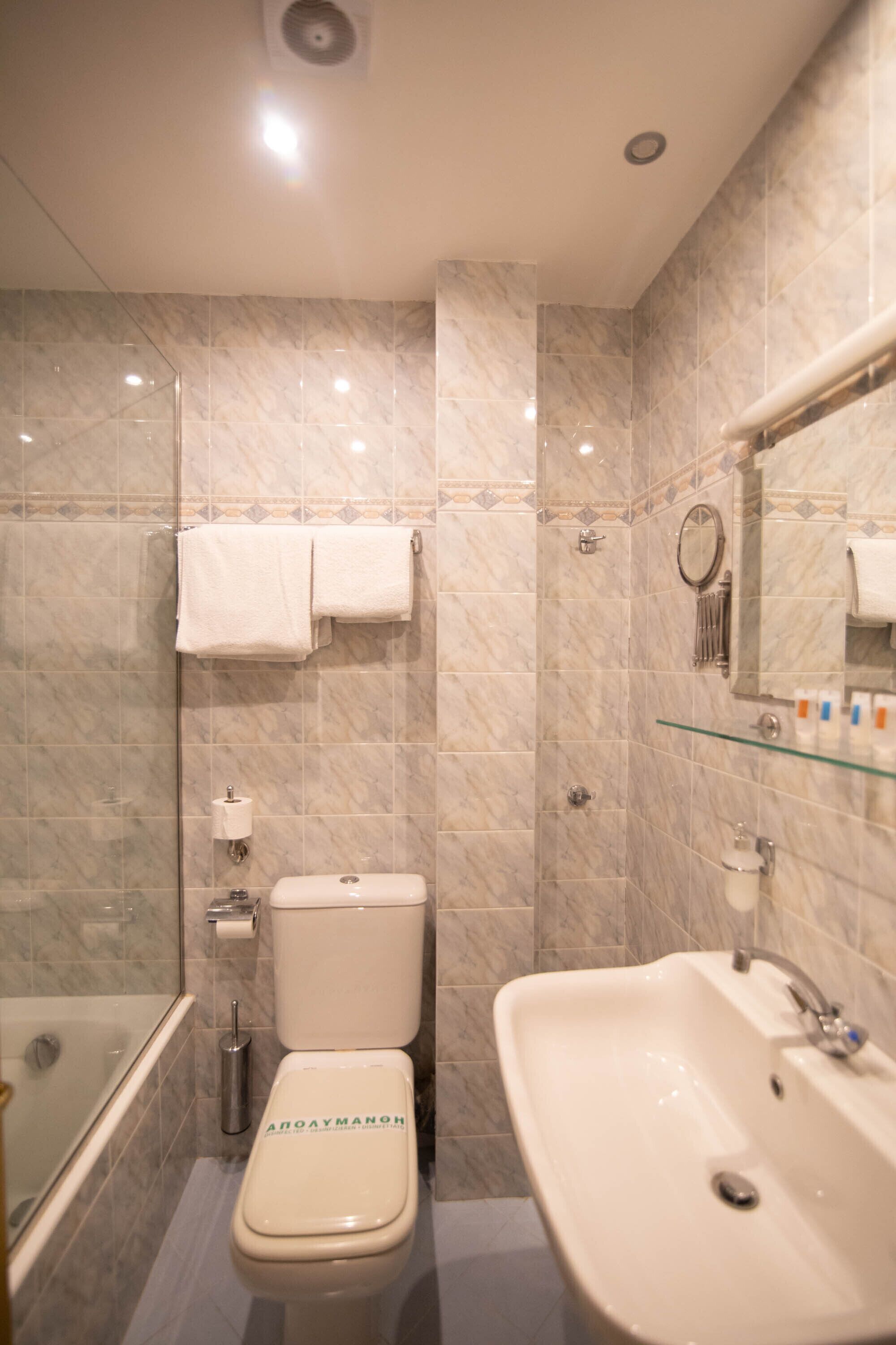 Un baño con inodoro, lavabo y ducha.
