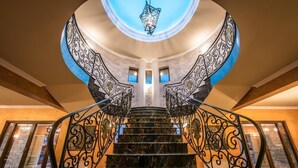 Eine prächtige Treppe mit aufwendiger schwarzer Geländer und einem Oberlicht am oberen Ende.