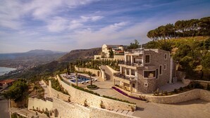 A stone villa with a swimming pool, terraced garden, and scenic mountain views.
