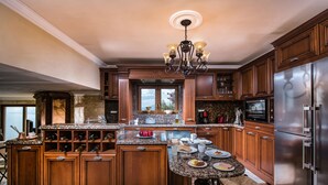 A spacious kitchen with wooden cabinets, a granite countertop, and stainless steel appliances.