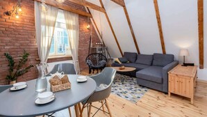 A cozy, modern tent-style accommodation with a dining area, seating, and a sofa.