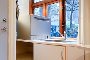 Enjoy cooking in this kitchen with a Bosch dishwasher, stainless steel sink, and a window overlooking a residential area.