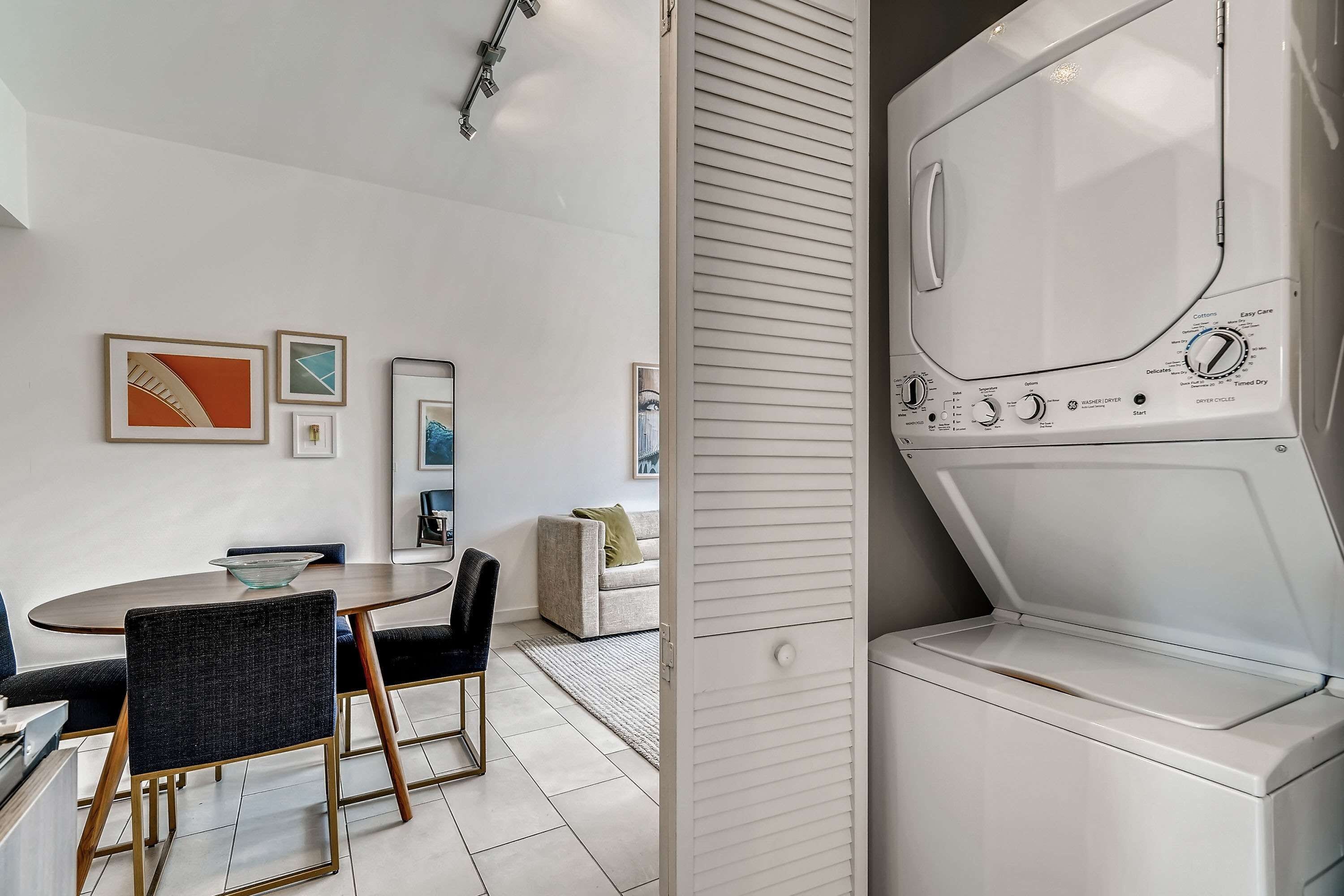 A modern kitchen with a round dining table, chairs, and a built-in oven.