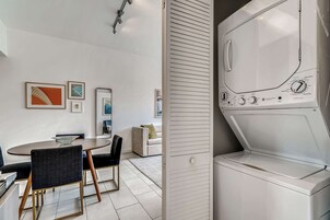 Cozinha moderna com mesa de jantar redonda, cadeiras e forno embutido.